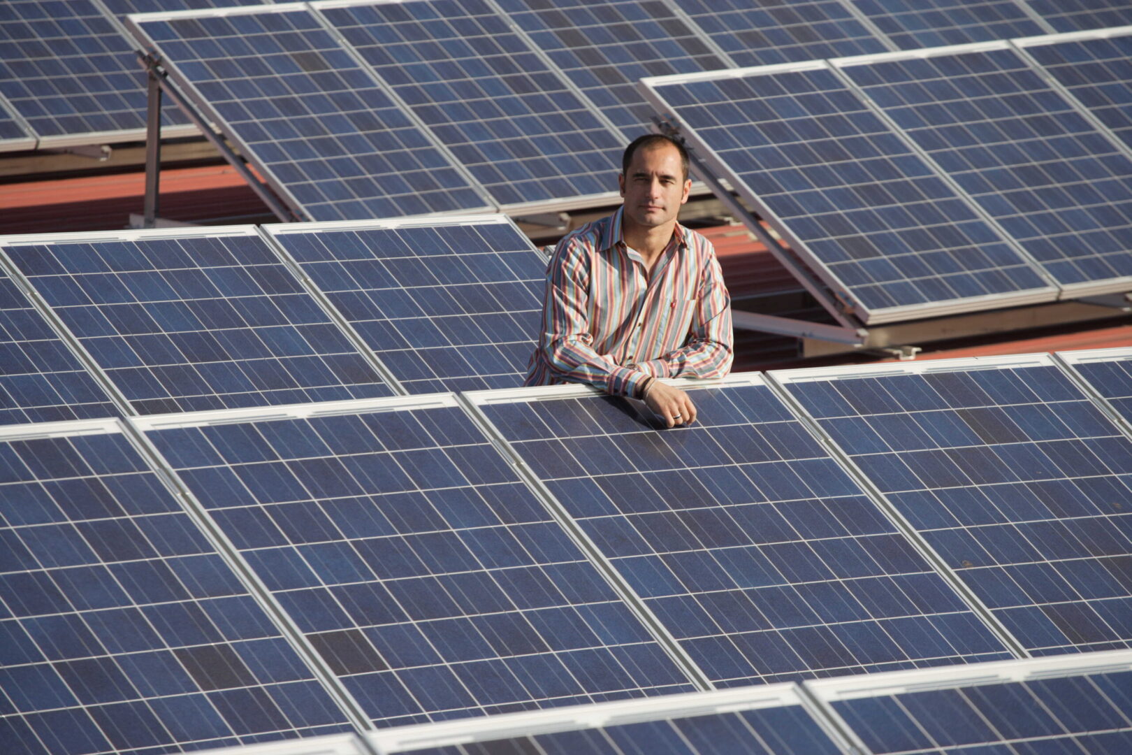 El dueño de la empresa se muestra en una imagen industrial rodeado de paneles solares.